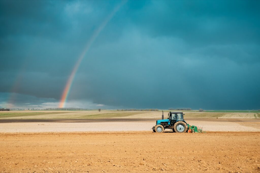 Tractor Plowing Field In Spring Season