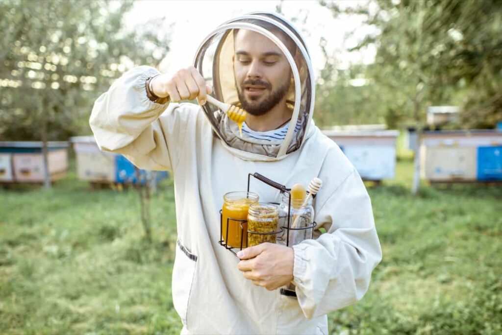 Beekeeper with honey on the apiary