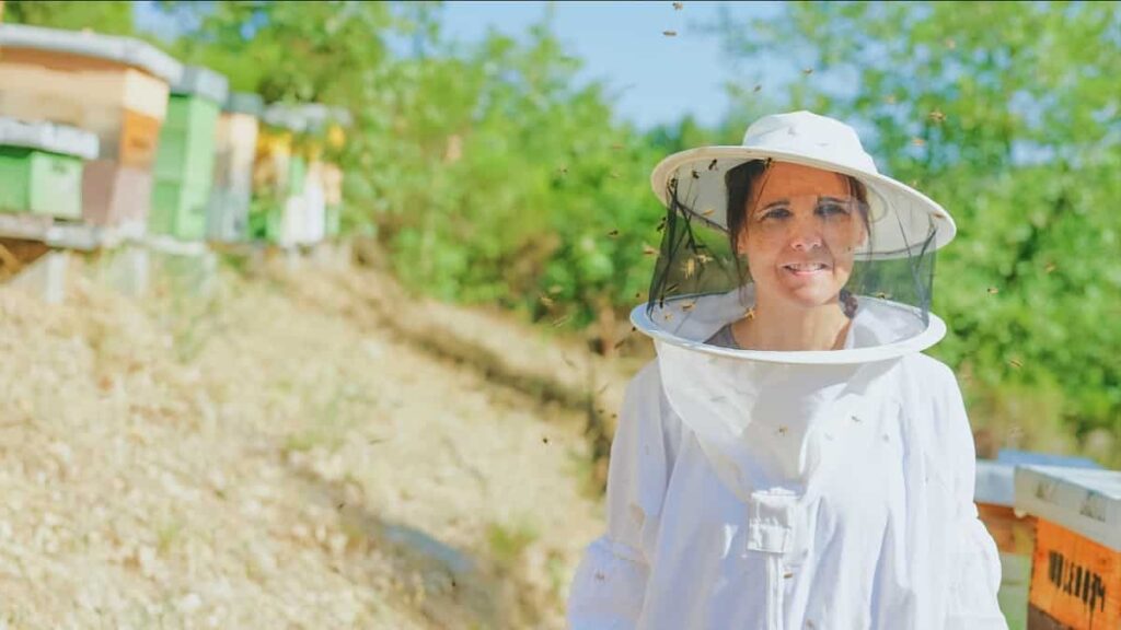 A female beekeeper in a field